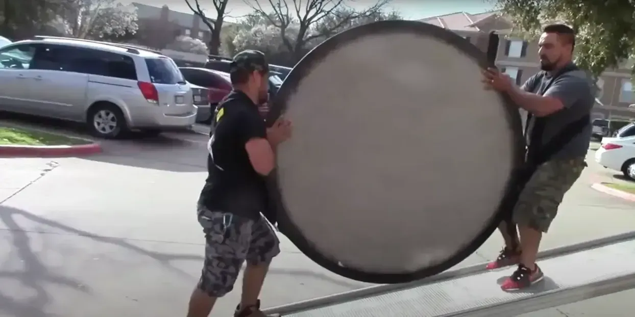 Professional movers carry furniture into a van